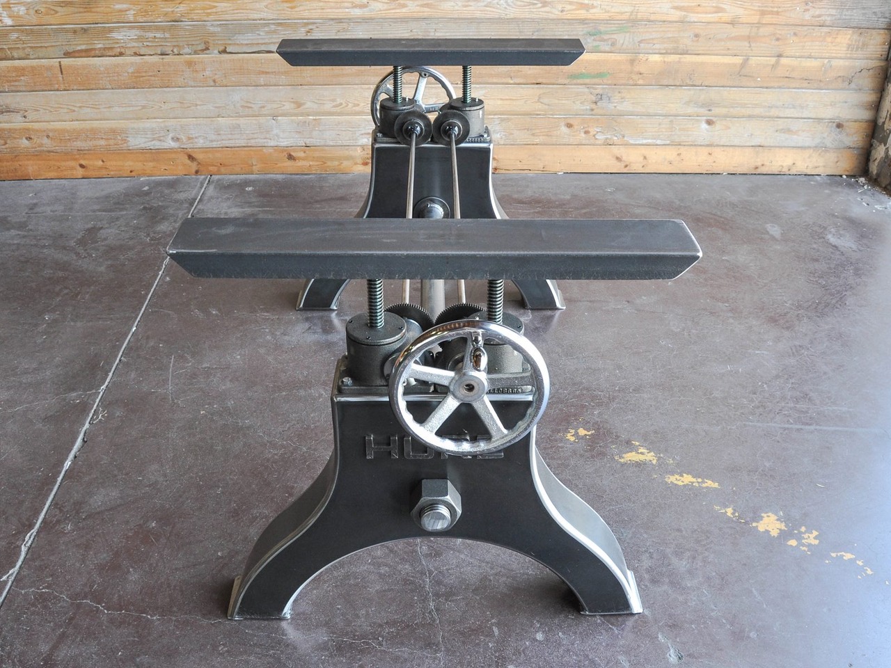 een zwart industrieel tafelonderstel met wiel om de tafel op te draaien.
